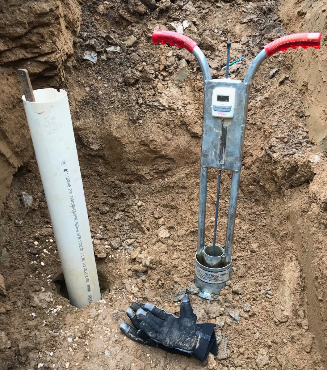 On the left is a groundwater monitoring hole with PVC casing. On the right is a double-ring infiltrometer test in-progress.